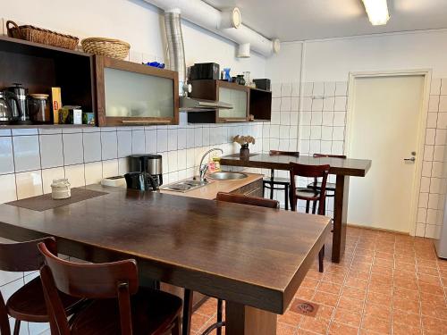 a kitchen with wooden tables and chairs in a room at Hostel Ingeri in Viljandi