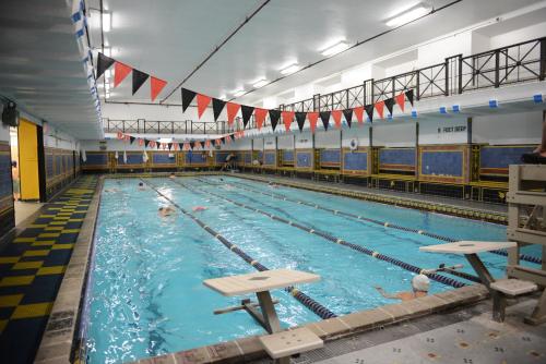 a large swimming pool with people in it at West Side YMCA in New York