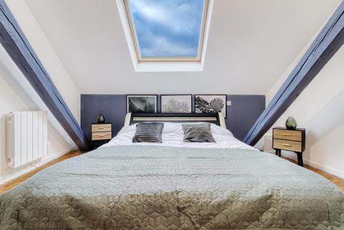 a bedroom with a large bed in a attic at Sous les Etoiles Metz Luxembourg Un-Séjour-à-Part in Clouange
