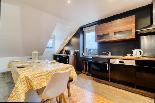 une cuisine avec une table et un chiffon de table jaune dans l'établissement Sous les Etoiles Metz Luxembourg Un-Séjour-à-Part, à Clouange