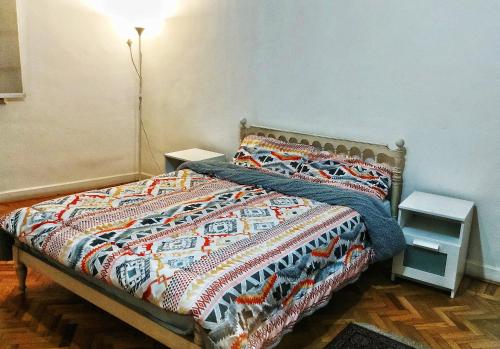uma cama com um edredão colorido num quarto em Jessy Charming apartment in Heliopolis em Cairo