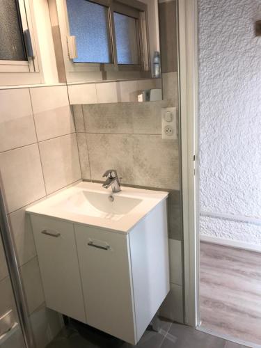 une salle de bain avec un lavabo blanc et une douche dans l'établissement APPARTEMENT CAUTERETS POUR 4 PERSONNES AVEC PARKING, à Cauterets