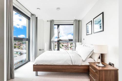 a bedroom with a bed and a large window at Modern, Stylish PENTHOUSE Apartment next to Wembley Stadium! in London