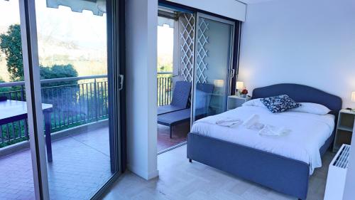 une chambre avec un lit et un balcon dans l'établissement Résidence avec piscine, Golf & plages à proximité - Palmazur Vacances, à Mandelieu-la-Napoule
