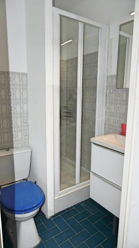 La salle de bains est pourvue d'une douche et de toilettes bleues. dans l'établissement Résidence avec piscine, Golf & plages à proximité - Palmazur Vacances, à Mandelieu-la-Napoule