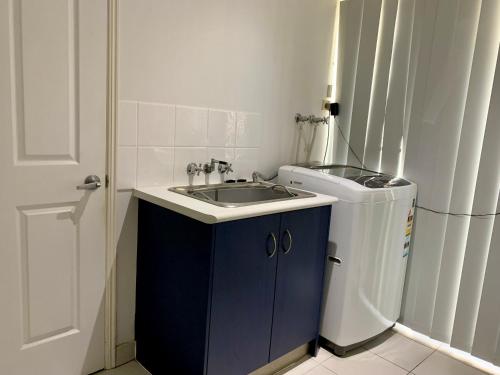 a bathroom with a sink and a trash can at Entire 4BR House close to Airport Hosted by Homestayz in Gladstone