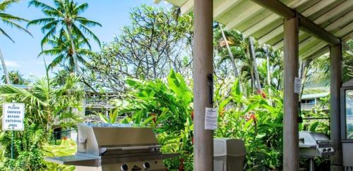 a patio with a grill and palm trees at Molokai Island Retreat with Beautiful Ocean Views and Pool - Newly Remodeled! in Ualapue