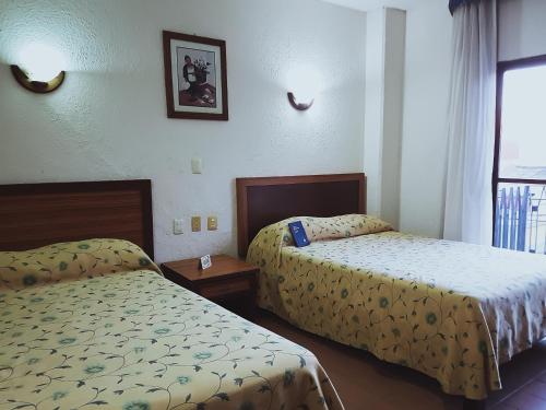 A bed or beds in a room at Hotel Plaza Independencia