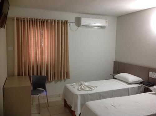 سرير أو أسرّة في غرفة في Itumbiara Palace Hotel
