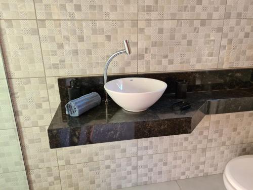 a bowl sink on a counter in a bathroom at Recanto H & E in Olímpia