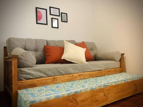 un sofá gris con almohadas encima en Hermoso departamento céntrico en Mendoza en Mendoza