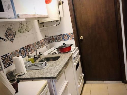 cocina pequeña con fregadero y fogones en Hermoso departamento céntrico en Mendoza en Mendoza