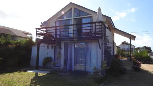 a house with a balcony on the side of it at Agradable Casa en Condominio Prados del Mar Tongoy RENOVADA in Tongoy