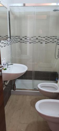 a bathroom with two toilets and a glass shower at Casa Vacanze Cerreto 1 in Miglianico