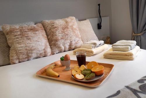 a tray of fruit and vegetables on a bed at Cozy Rooms - Great Bus Connections - Free Parking in Mosta