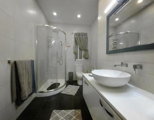 a white bathroom with a sink and a shower at Cozy Rooms - Great Bus Connections - Free Parking in Mosta