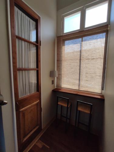 a room with a door and a window and two stools at Hostal Dinamarca in Valparaíso