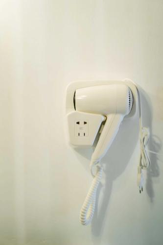 a white hairdryer hanging on a wall at Good Time Relax Resort in Kampot
