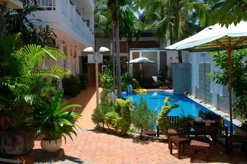 a courtyard with a swimming pool in a building at Qli Hotel in Mui Ne