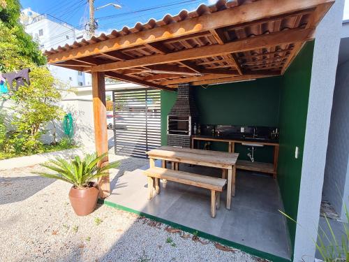 un patio con una mesa de madera y un banco en Residencial Rumo ao Mar - Bombinhas-SC, en Bombinhas