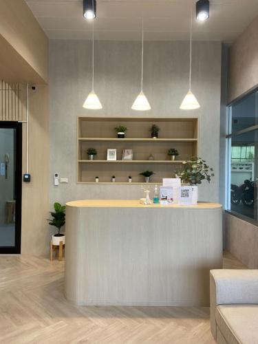 a lobby with a reception counter with lights at Next Bird Suite SHA in Nonthaburi