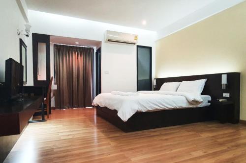 a bedroom with a large bed and a television at Next Bird Suite SHA in Nonthaburi