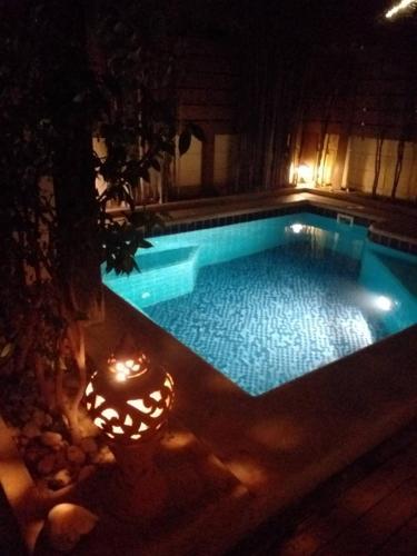 a swimming pool at night with a candle in the middle at BTC Hua Hin Home managed by BTC Boutique Resort in Hua Hin