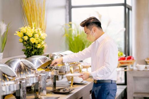 a man standing in a kitchen preparing food at Good Time Relax Resort in Kampot