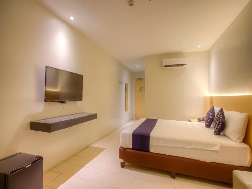 En eller flere senge i et værelse på Capital O 827 Speciale Hotel