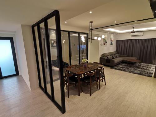 a dining room with a table and a living room at Pax6+2 Melaka Famous Homestay Klebang Homefeel in Melaka