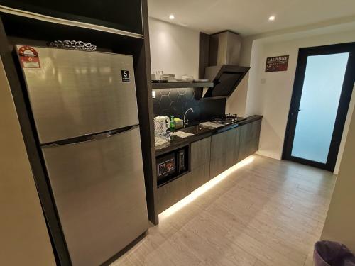 a kitchen with a stainless steel refrigerator and a counter at Pax6+2 Melaka Famous Homestay Klebang Homefeel in Melaka