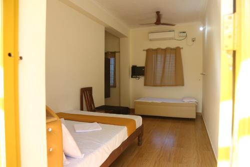 a hotel room with two beds and a window at Harsha Haritha Residency in Cuddalore