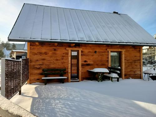 a log cabin with a roof in the snow at Chutor Grzegorza in Wysowa-Zdrój