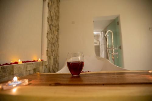 a glass of wine sitting on a table in a bathroom at ROSA BELLA in Nizwa