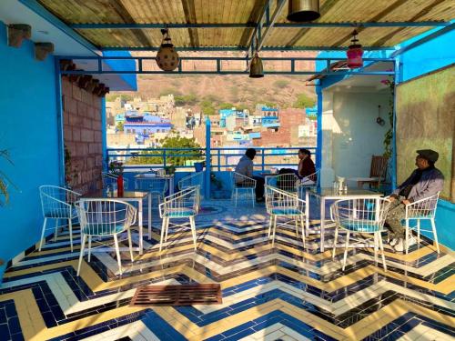 a restaurant with blue chairs and a view of the city at Swiss House in Jodhpur