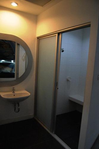 a bathroom with a shower and a sink and a mirror at The Adventure Hotel in Chiang Mai