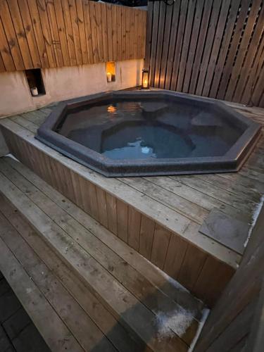a jacuzzi tub in a wooden deck at Varmi Guesthouse Apartments & rooms in Hveragerði