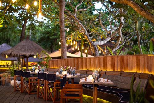 a restaurant with tables and chairs and a fence at Melia Bali in Nusa Dua