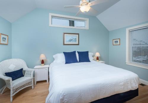 a blue bedroom with a bed and a chair at Heron Neck Cottage at One Long Beach in York Beach