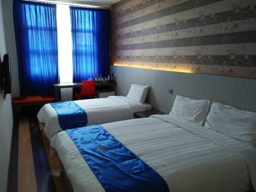 Pokój hotelowy z 2 łóżkami i czerwonym krzesłem w obiekcie 4orty Inn w mieście Bintulu