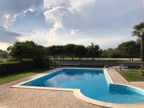 a swimming pool in the middle of a yard at Beautiful Modern Villa in Albarella by Beahost in Isola Albarella