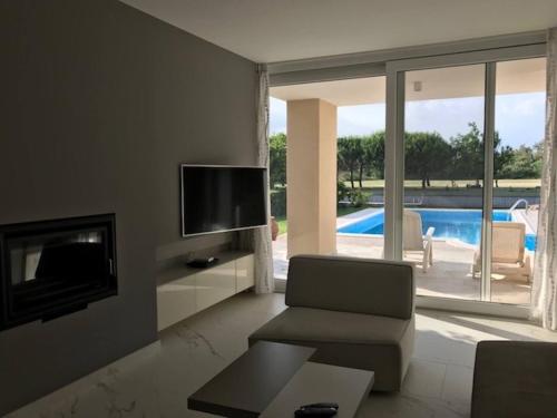 uma sala de estar com uma televisão e um sofá e uma televisão em Beautiful Modern Villa In Isola Albarella em Ilha Albarella