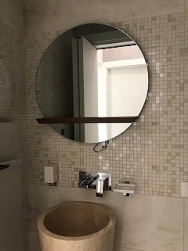 a bathroom with a round mirror and a sink at Beautiful Modern Villa in Albarella by Beahost in Isola Albarella