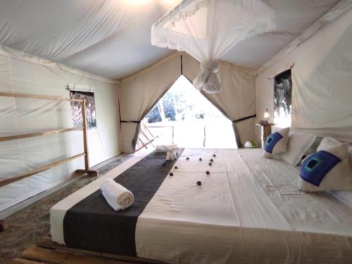 a bedroom with a large bed in a tent at Jungle View River Camping in Udawalawe