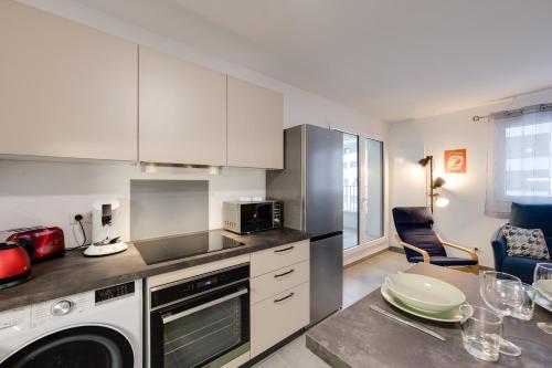 a kitchen with white cabinets and a dishwasher at Le Concert - Beautiful appartment with garage for 4 people near beach in Annecy