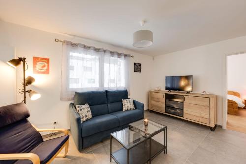 ein Wohnzimmer mit einem Sofa und einem TV in der Unterkunft Le Concert - Beautiful appartment with garage for 4 people near beach in Annecy