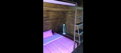 a small bed in a room with a ladder at เขาค้อ อันนาอิม รีสอร์ท in Ban Thung Samoe