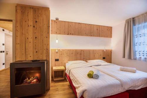 une chambre d'hôtel avec un lit et une cheminée dans l'établissement Chalet Osmar Suite 1, à Campitello di Fassa