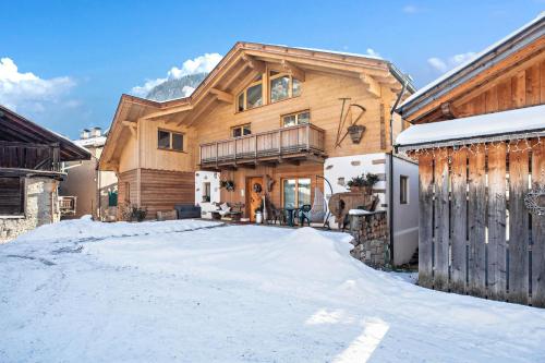 a log home in the snow with a driveway at Chalet Osmar Suite 1 in Campitello di Fassa