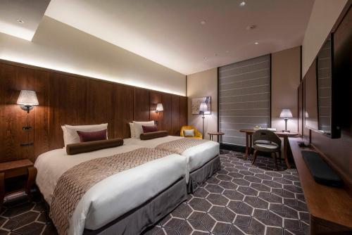 a hotel room with a large bed and a desk at Hotel GrandBach Tokyo Ginza in Tokyo
